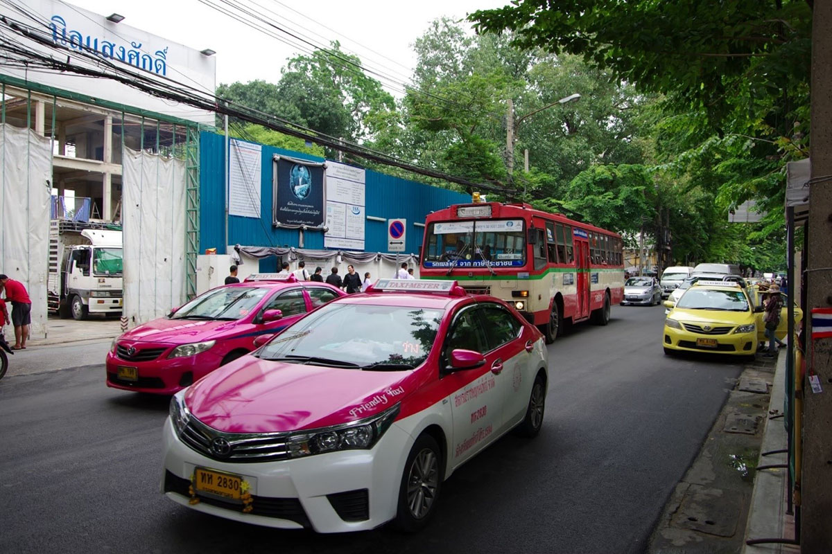 写真①：左側ピンク色タクシー2台、右奥赤色路線バス